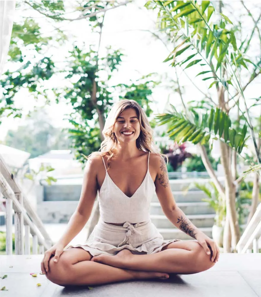 Guest meditating in a tropical garden setting